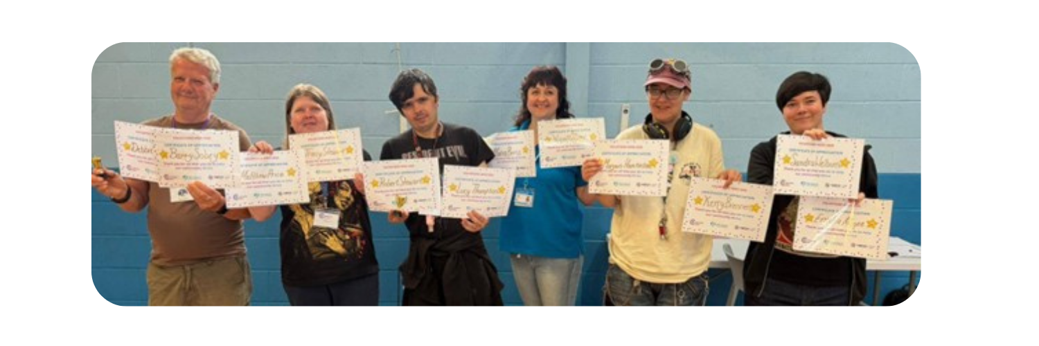 Six people together smiling and holding multiple certificates in all their hands.