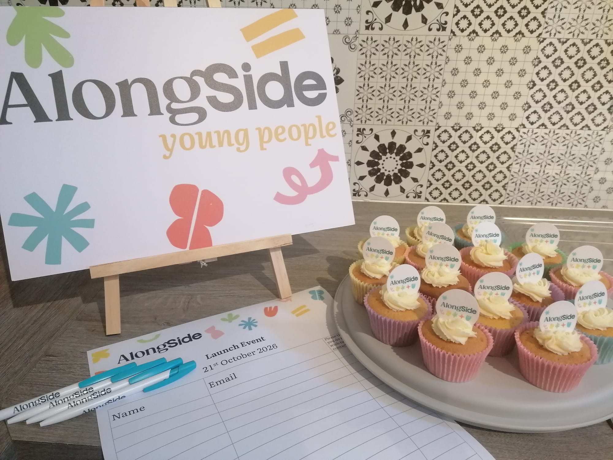 Photo of branded cupcakes and banner from AlongSide's launch event