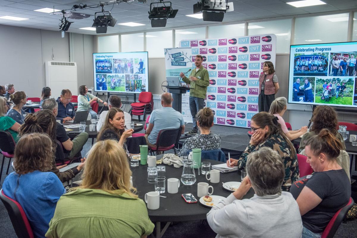 A wide view of the conference with lots of people listening to the Going Green Together Team 