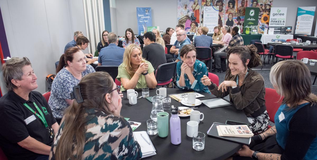 A selection of delegates around a circular table in discussion