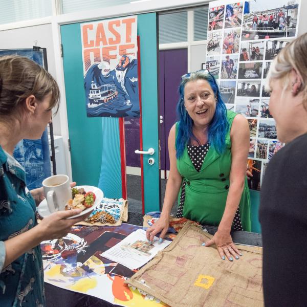 People smiling looking at textiles